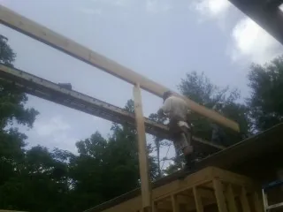 Carpenter setting a ridge beam over a new addition frame — Ice Dam Removal by Roofing Brothers in Corbin