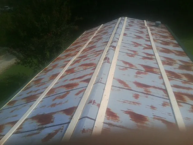 Rusted metal roof panels with new wood purlins before replacement — Storm Damage Roof Repair in Corbin by Roofing Brothers